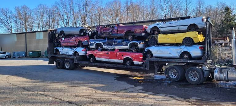 Junk cars stacked on a car hauler trailer at the yard, ready to be recycled